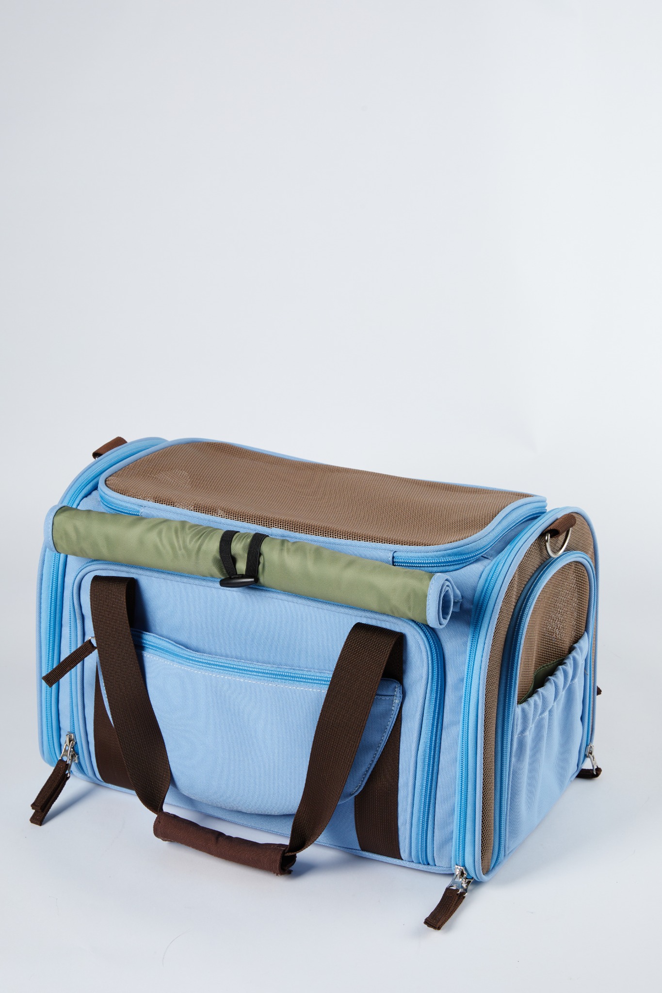 Rear three-quarter view of the blue Wander Meow carrier with its top mesh, rolled privacy cover, rear panel, handles, zippers, and side mesh visible.