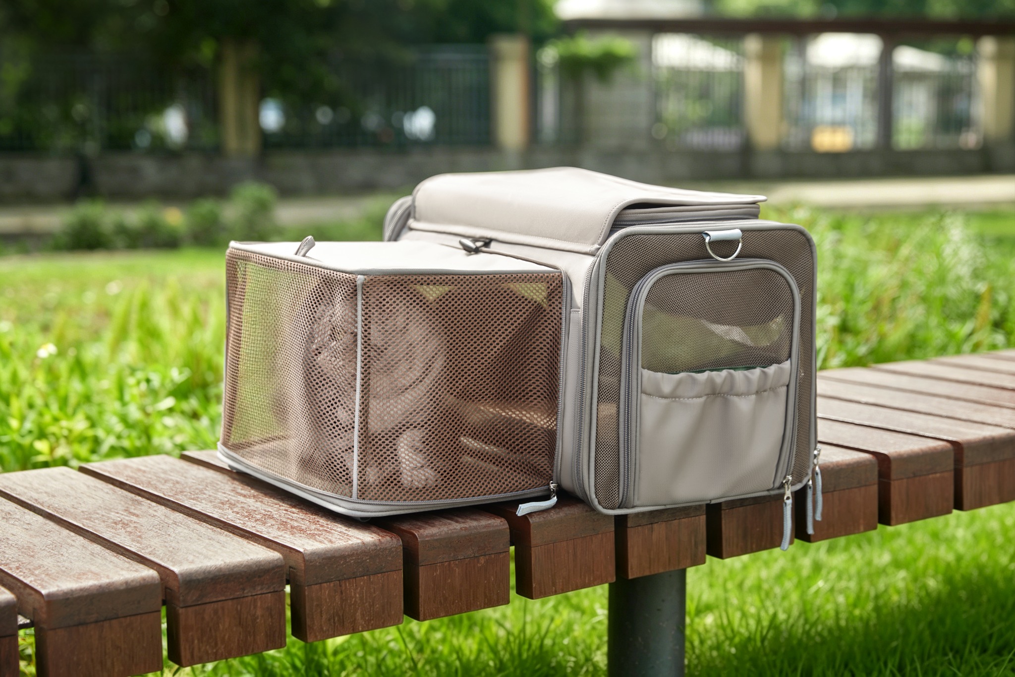 Gray Wander Meow carrier with its mesh rest area expanded on an outdoor bench while stationary.